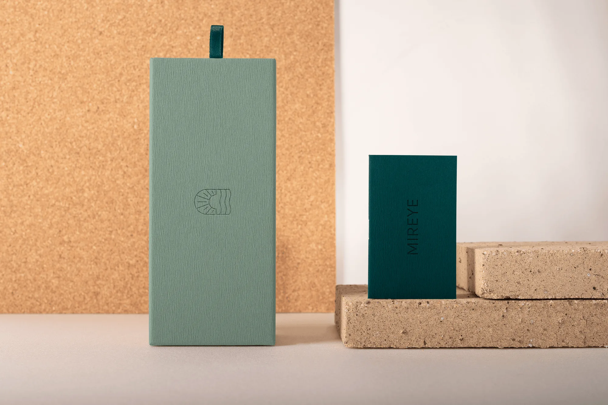 Mireye packaging: the sage case standing beside a deep green booklet